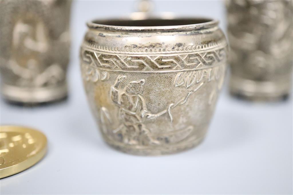 A pair of Chinese white metal pepperettes, 7cm, a similar salt, small goblet and a coin.